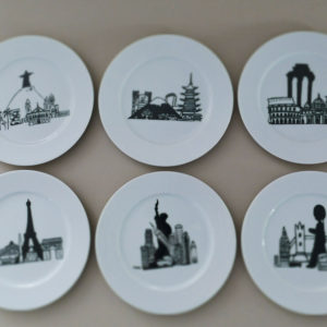 le coffret mini monde comporte 6 assiettes à dessert en porcelaine blanche avec 6 dessins originaux représentant des grandes villes : Paris, New York, Londres, Rome, Tokyo et Rio - création originale d'assiettes et compagnie éditée par la maison revol