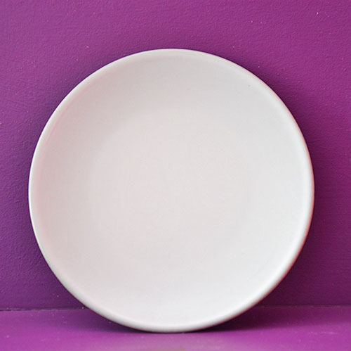assiette rouge à partager en porcelaine noire et émaillage blanc par les ateliers Revol, fabrication française