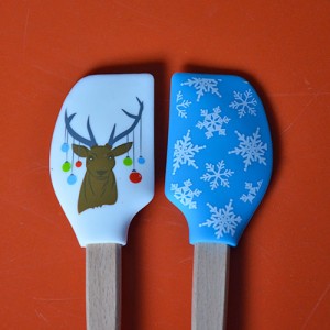 deux mini spatules tovolo de la collection spatulart pour évoquer noel avec le cerf et ses guirlandes et l'imprimé neige.... très pratiques pour cuisiner