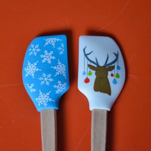 deux mini spatules tovolo de la collection spatulart pour évoquer noel avec le cerf et ses guirlandes et l'imprimé neige.... très pratiques pour cuisiner