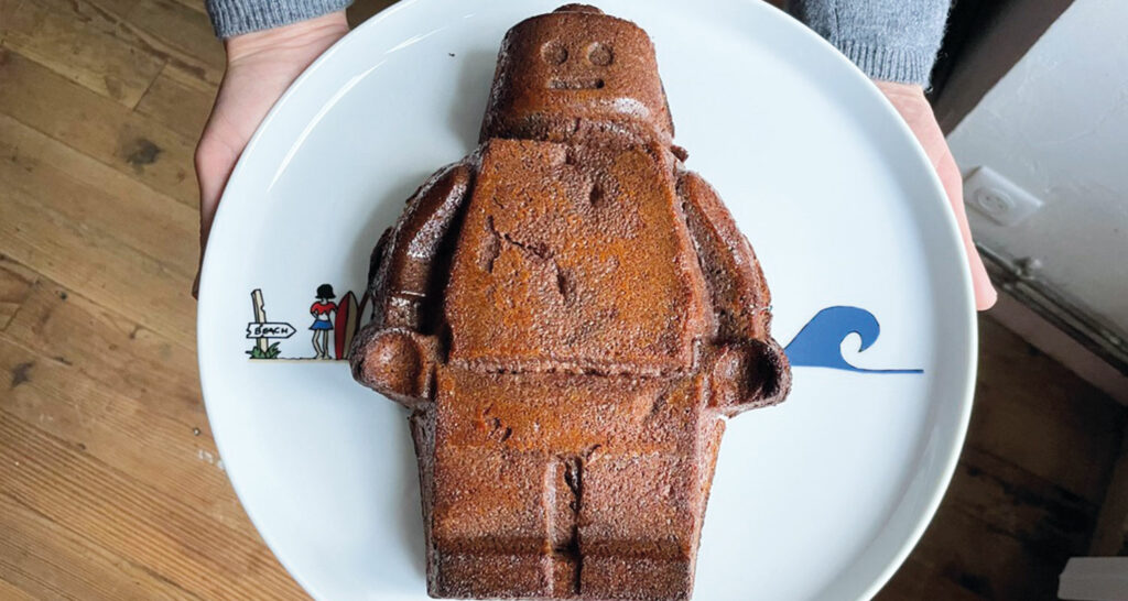 gateau monsieur lego en grand format, une recette de gateau au chocolat parfaite et présentation sur un plat la plage par assiettes et compagnie