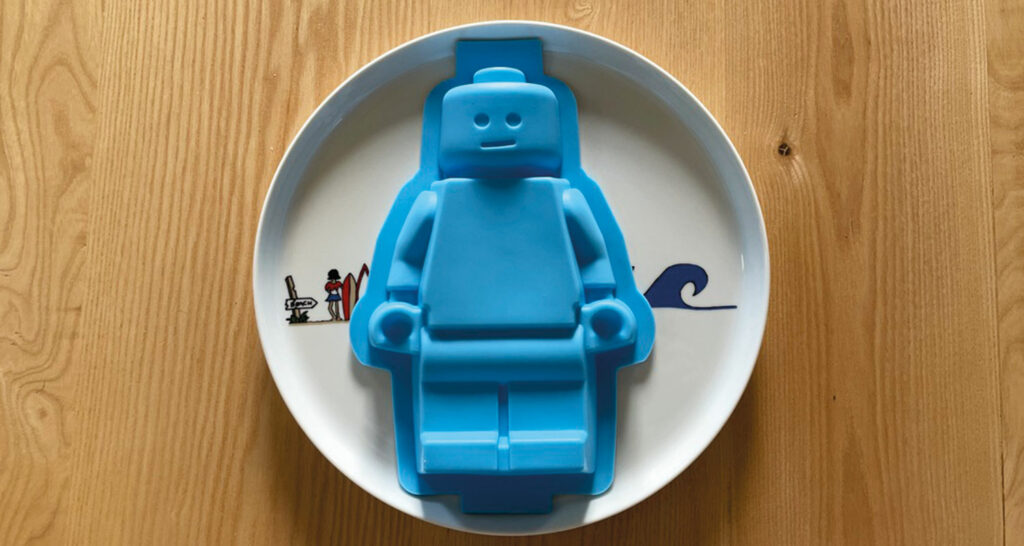 gateau monsieur lego en grand format, une recette de gateau au chocolat parfaite et présentation sur un plat la plage par assiettes et compagnie