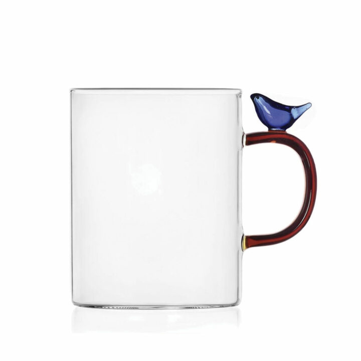 un mug en verre avec un oiseau bleu posé sur l'anse de la fabrique ichendorf milano se marie parfaitement avec les collections assiettes et cie