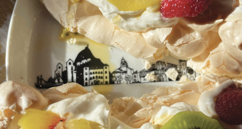 la pavlova Lauburu est en forme de croix basque et se décline avec ttrois variétés de kiwis, présentée sur un plat rond pays basque par assiettes et compagnie