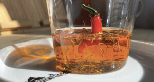 voici une recette d'huile piquante pour pizza, un régal pour donner du peps à vos pizzas mais aussi aux pates et aux salades, présentation sur une assiette basque et dans un verre piment sur assiettes et compagnie