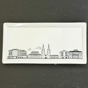 le plat à cake Bayonne est une création originale d'assiettes et compagnie, pour mettre en lumière sa ville de coeur ... la ligne magique de tous les plus beaux monuments de Bayonne, fief du pays basque et des fêtes de bayonne. plat e porcelaine française de la manufacture Revol